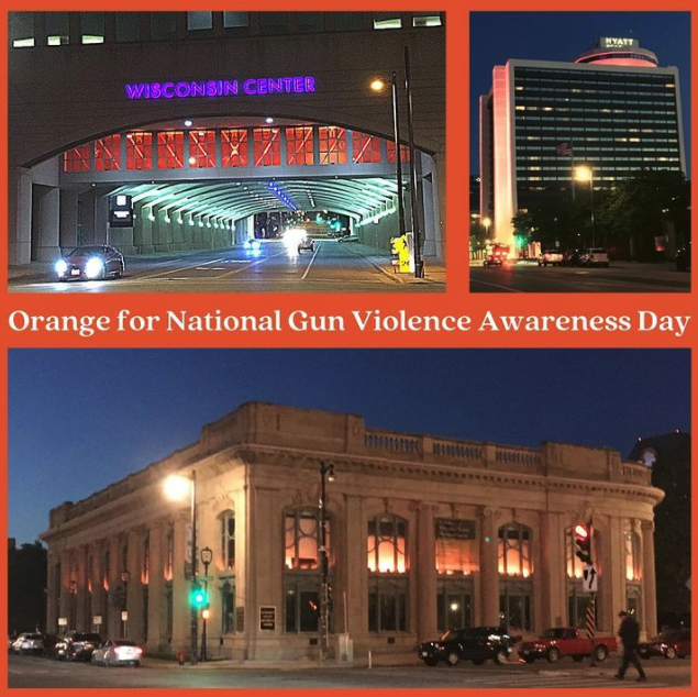 Image shows several large buildings in Milwaukee lit up in orange lights in honor of National Gun Violence Awareness Day