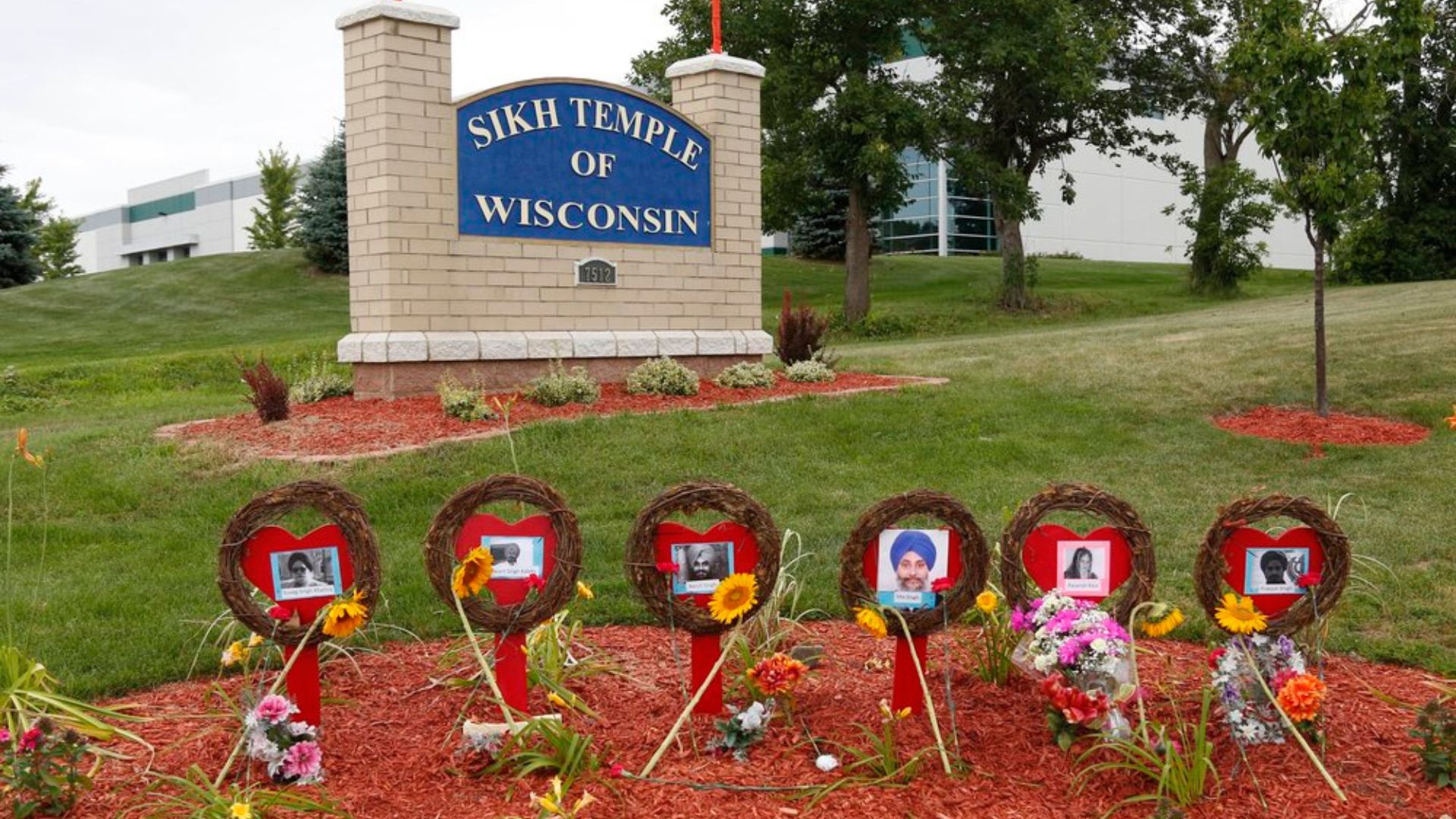 Photograph of a memorial for the victims of the Sikh Temple shooting in Wisconsin in front of the temple's sign. We are sharing the image to promote the upcoming Chardi Kala Community Event.