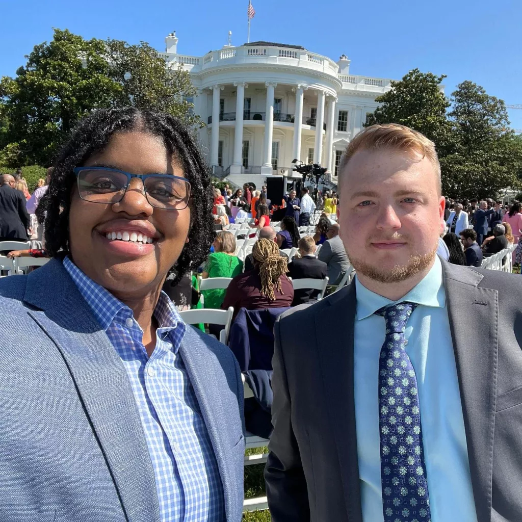 In the background is the White House. The foreground shows WAVE staffers in suits smilling.