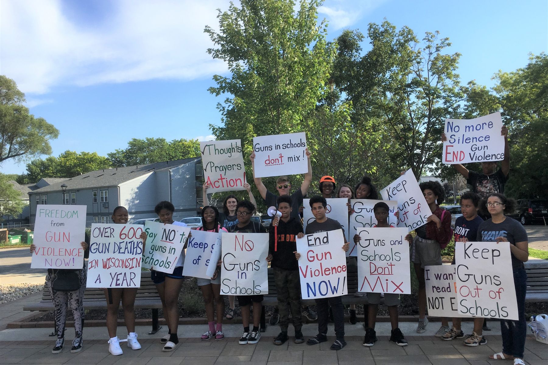 A group of youth hold signs that express passion for ending gun violence