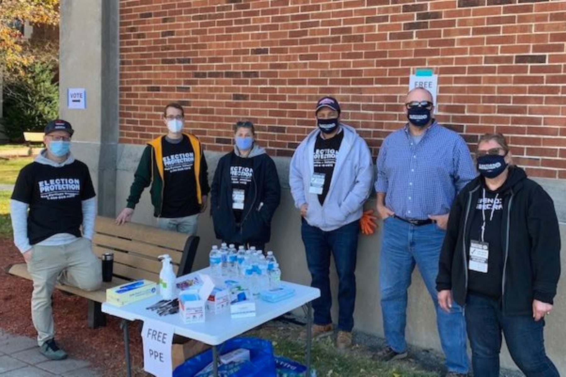 WAVE participated in distributing personal protective gear for the November election. 6 WAVE supporters and volunteers stand at a table with free PPE items