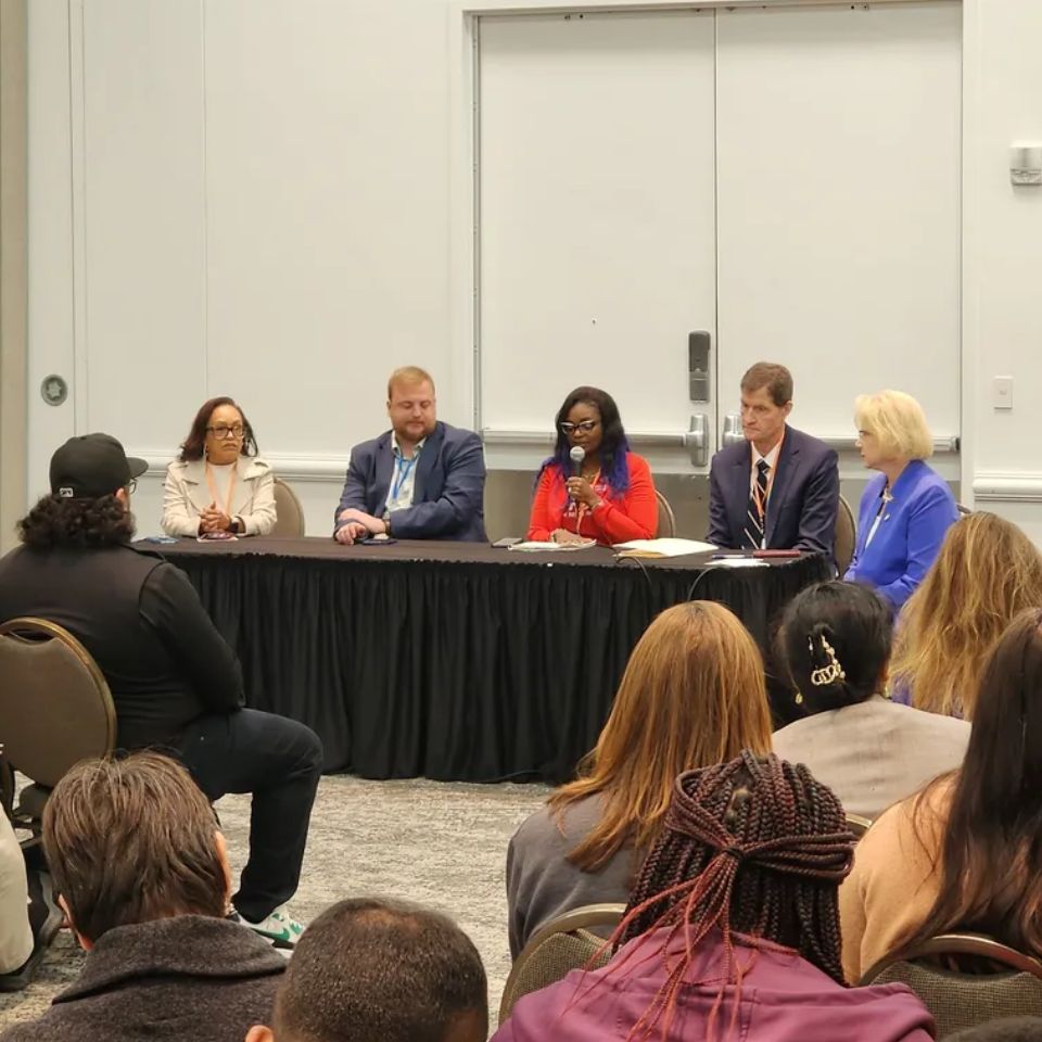 Four people sit at a table, speaking during a panel. The second person from the left is WAVE's Director of Policy and Program, Nick Matuszewski.