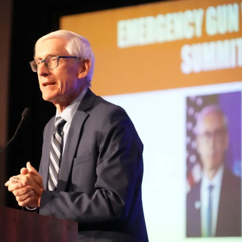 Governor Evers speaks into a microphone during the Gun Violence Summit