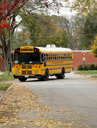 A yellow school bus rounds the corner