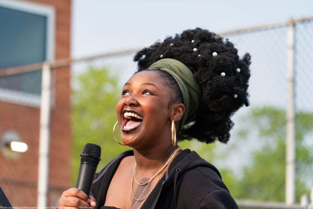 A woman speaks and looks to the sky with joy and hope.