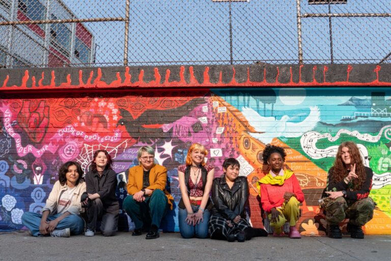 WAVE Youth Advisory Board and Artists Against Gun Violence members pose in front of the mural they designed and created